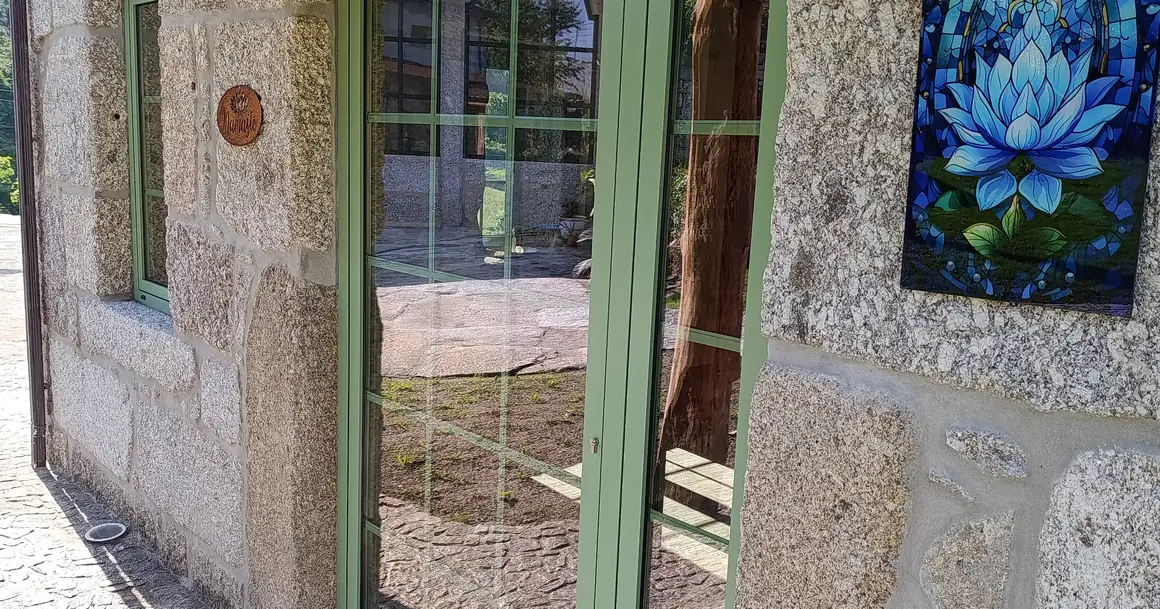 Una puerta verde en el muro de granito de Casa Lotus Azul